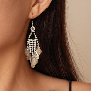 Close-up of silver leaf tassel earrings with white rhinestones on model's ear