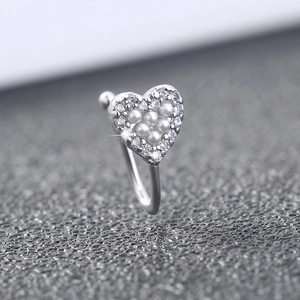 Macro detail of silver heart nose clip featuring white pearls and clear diamonds