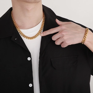 Men's gold Cuban chain set featuring a thick necklace and bracelet on a male model