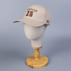 Casquette de baseball beige avec broderie Attitude 35 sur une tête de mannequin