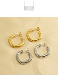 Detailed view of gold and silver titanium steel hoop earrings with twisted rope texture