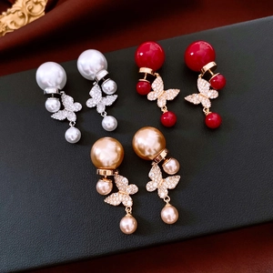 Détails de boucles d'oreilles papillon en or 18k avec perles sur support en cuir noir
