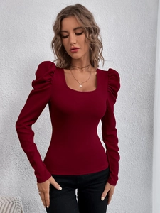 Detail of burgundy square neck top with puff sleeves and slim fit textured fabric