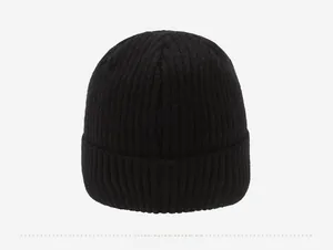 Macro shot of the black ribbed knit texture and wide folded brim on the winter beanie