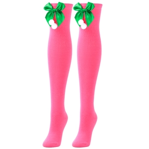 Close-up of pink over-knee socks with green bow and white pompom holiday detail