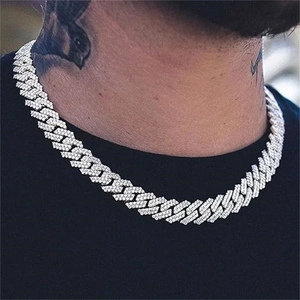 Close-up of a silver iced-out Cuban link chain necklace on a male model's neck