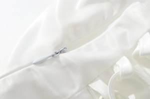 Detailed close-up of white satin fabric featuring a high-quality invisible zipper