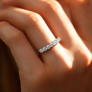 Detail of 925 sterling silver ring with seven round-cut moissanite stones on a finger