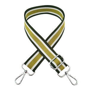 Dettaglio della tracolla regolabile in tessuto a righe verde e oro con ganci in metallo