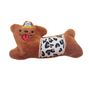 Plush brown bear brooch with birthday hat and leopard pattern detail on white background