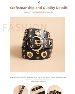 Detail of black leather punk belt with heart shaped metal eyelets and gold buckle