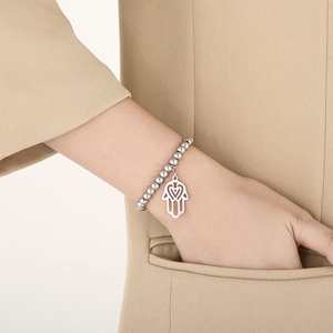 Detail of silver beaded bracelet featuring a hollow Hamsa Hand charm on wrist