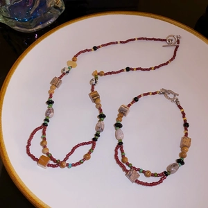 Macro detail of bohemian ceramic flower and multi-stone beaded necklace with silver OT clasp