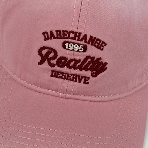 Detailed view of vintage pink cotton baseball cap with retro 1995 letter embroidery
