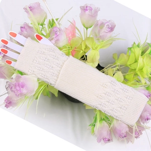 Detail of cream white knit arm warmers with intricate hollow crochet leaf patterns