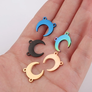 Macro view of crescent moon steel charms in blue, black, rainbow, and gold finishes