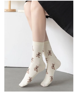Detailed close-up of cream-colored mid-calf socks featuring cute brown bear patterns