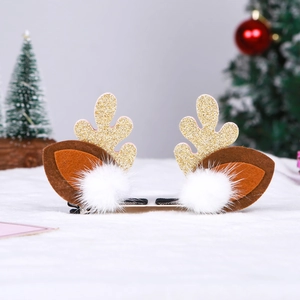 Detail of Christmas reindeer antler hair clips with gold glitter and white plush pom poms