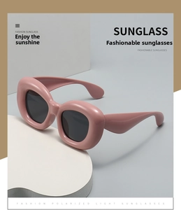 Detailed close-up of pink oversized bubble sunglasses featuring polarized dark grey lenses
