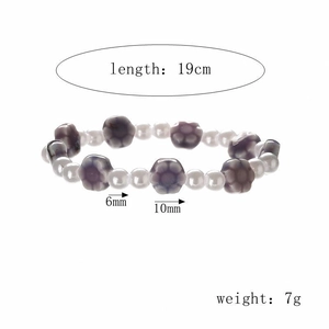 Detail view of pearl beaded bracelet with purple ceramic flowers and size specifications