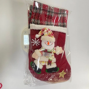 Detail shot of a large plaid snowman Christmas stocking on a scale weighing 238.5 grams