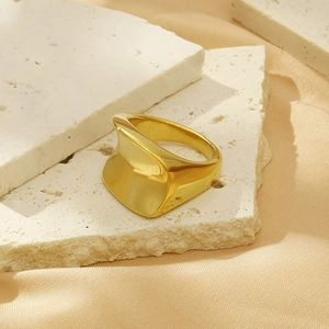 Detail of 18K gold plated titanium ring on travertine stone and silk fabric background