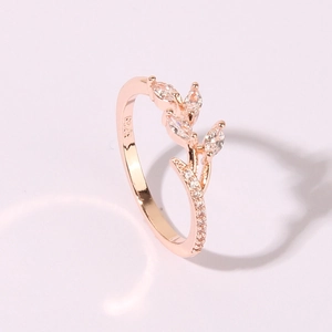 Anello in oro rosa con foglie di zircone e incisione S925 su sfondo rosa chiaro