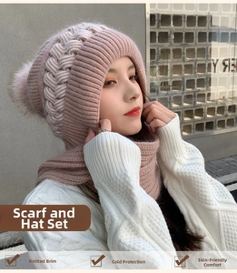 Close-up of pink knit winter hat and scarf set with thick cable weave and soft pom-pom