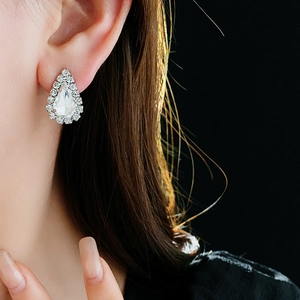 Gros plan de boucles d'oreilles goutte serties de diamants sur un mannequin élégant