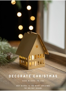 Golden house-shaped metal candle holder with star cutouts on a festive wooden windowsill