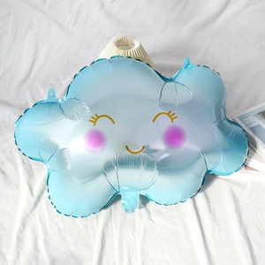 Close-up of blue cloud-shaped foil balloon with cute smiley face on white fabric
