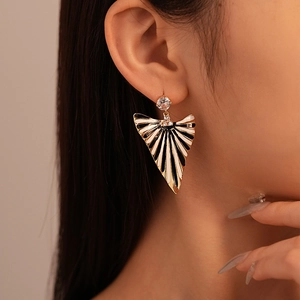 Close-up of black and white striped enamel triangle earring with zircon stone on model