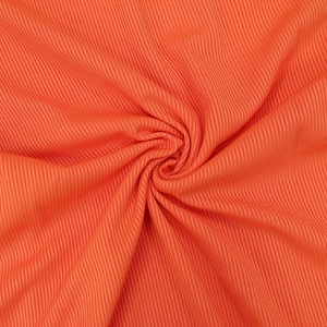 Detailed macro view of orange ribbed knit fabric texture with elastic vertical stripes