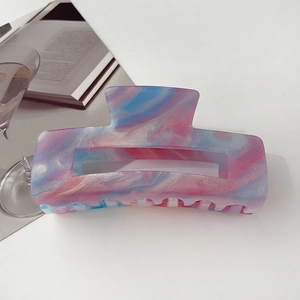 Detailed close-up of iridescent pastel marble resin hair claw with sturdy grip design