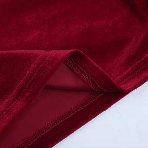 Dettaglio della trama del velluto rosso intenso e cuciture professionali dell'abito