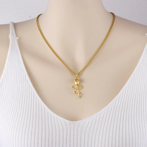 Detail of a 3D gold rose pendant necklace on a delicate chain worn by a model