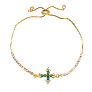 Detailed view of adjustable gold cross bracelet featuring green zircon and clear crystals