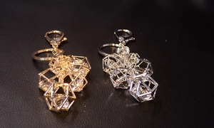 Close-up of geometric hollow frames with inlaid crystals in gold and silver finishes