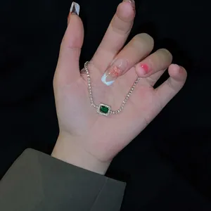 Elegant emerald-cut green gemstone bracelet with sparkling zircon halo and pavé chain