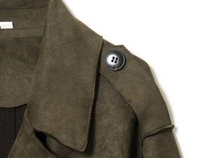 Close-up of olive green suede trench coat featuring shoulder straps and black buttons