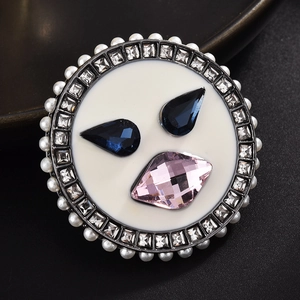 Macro detail of luxury brooch with deep blue gems, pink crystals and pearls