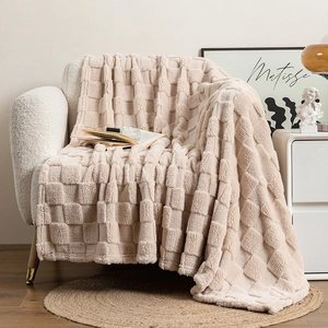 Detailed texture of thick cream checkerboard fleece blanket draped on a cozy armchair