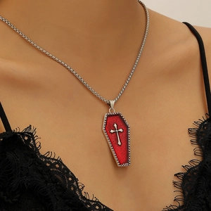 Close-up of Gothic coffin necklace with red glitter inlay and silver cross pendant on model