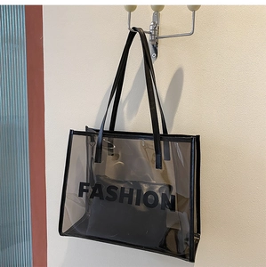 Detail of grey transparent PVC tote bag with Fashion lettering and black inner pouch