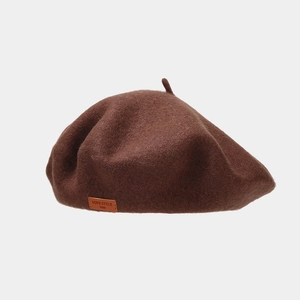 Detail of wool beret texture with a dark brown leather label and vintage top stalk