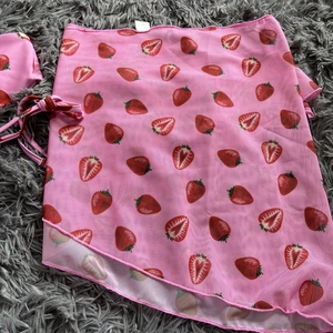 Detailed view of pink mesh sarong featuring strawberry prints and waist tie closure
