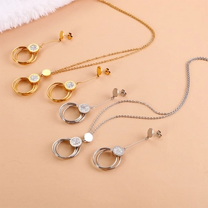 Elegant stainless steel jewelry set with crystal-encrusted circles on plush background