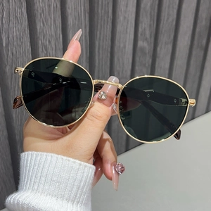 Close-up of retro round metal sunglasses with gold frames and dark polarized lenses