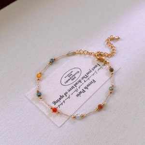 Close-up of golden link chain necklace with colorful beads and adjustable lobster clasp
