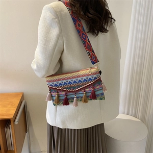 Dettaglio della borsa a tracolla etnica intrecciata con motivi colorati e lunghe nappe